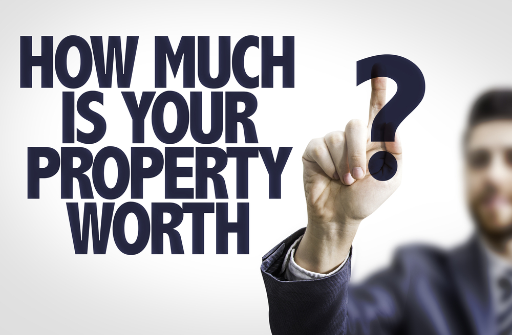 Business man pointing to transparent board with text How Much is your Property Worth?-1